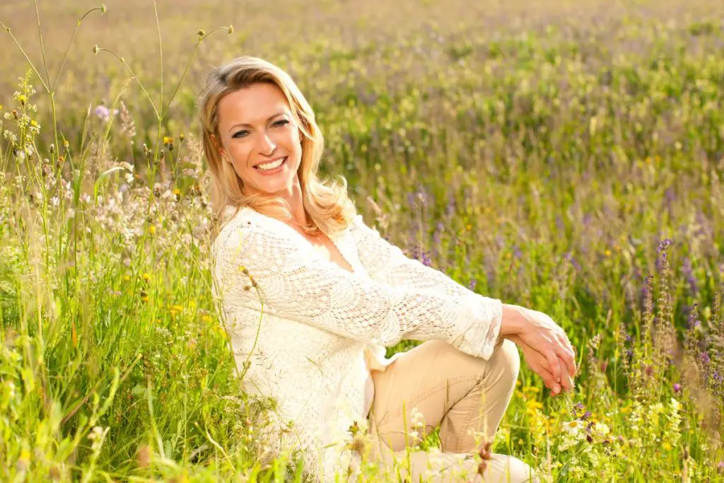 femme souriante en champs de plantes